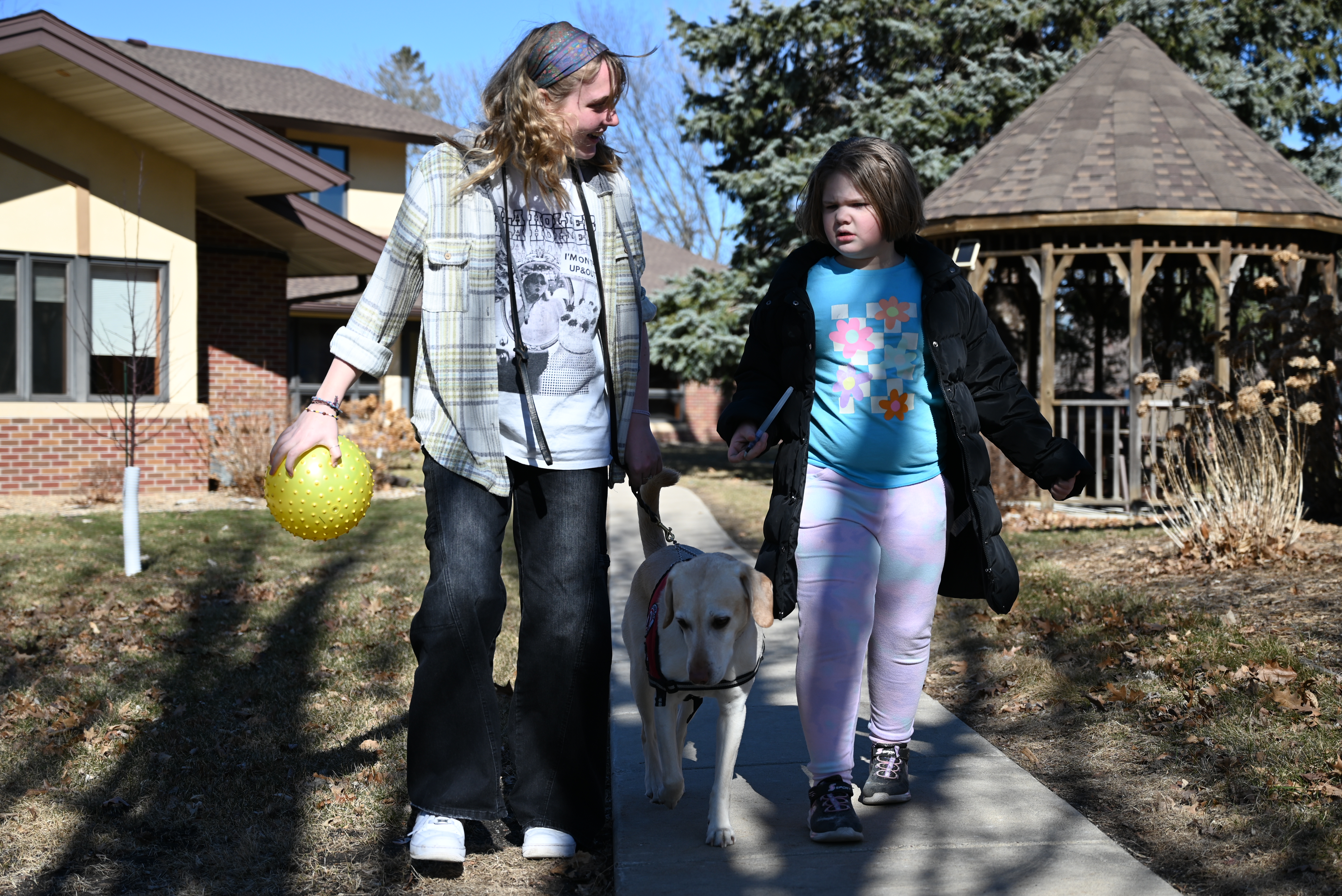 Caretaker and client walking with dog on LBSA campus